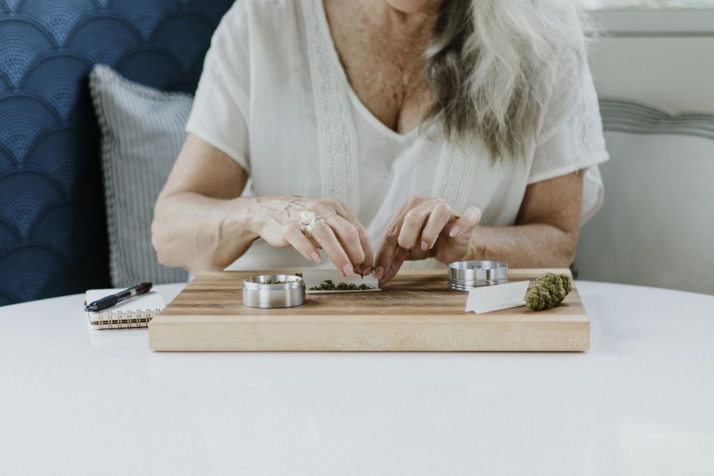 Older woman rolling a cannabis joint