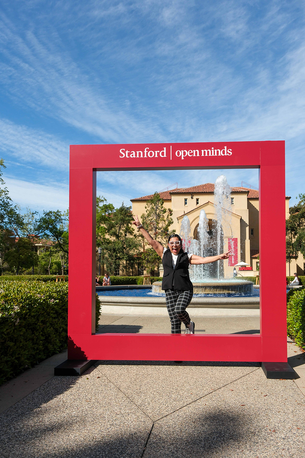 A person strikes a joyful pose in a large, red frame with 