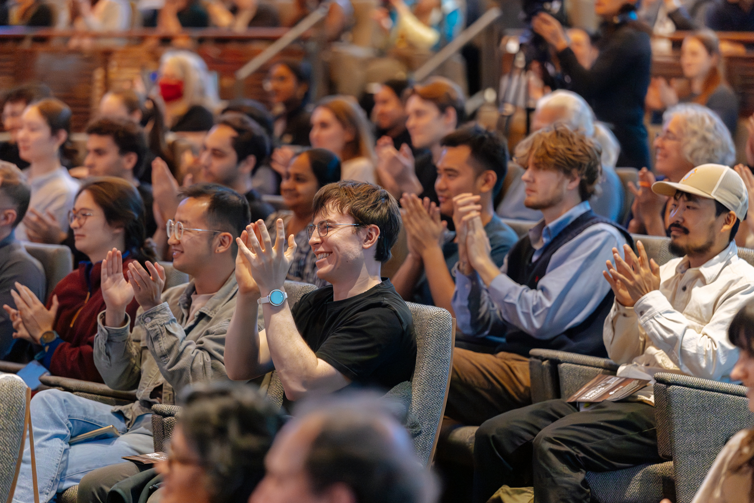 Audience members applauding and smiling during the event.