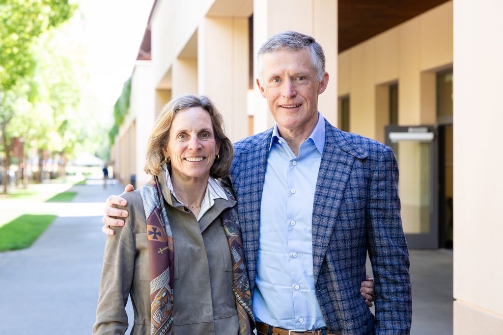 Diane and Andreas Halvorsen pose together outdoors with a campus setting in the background.