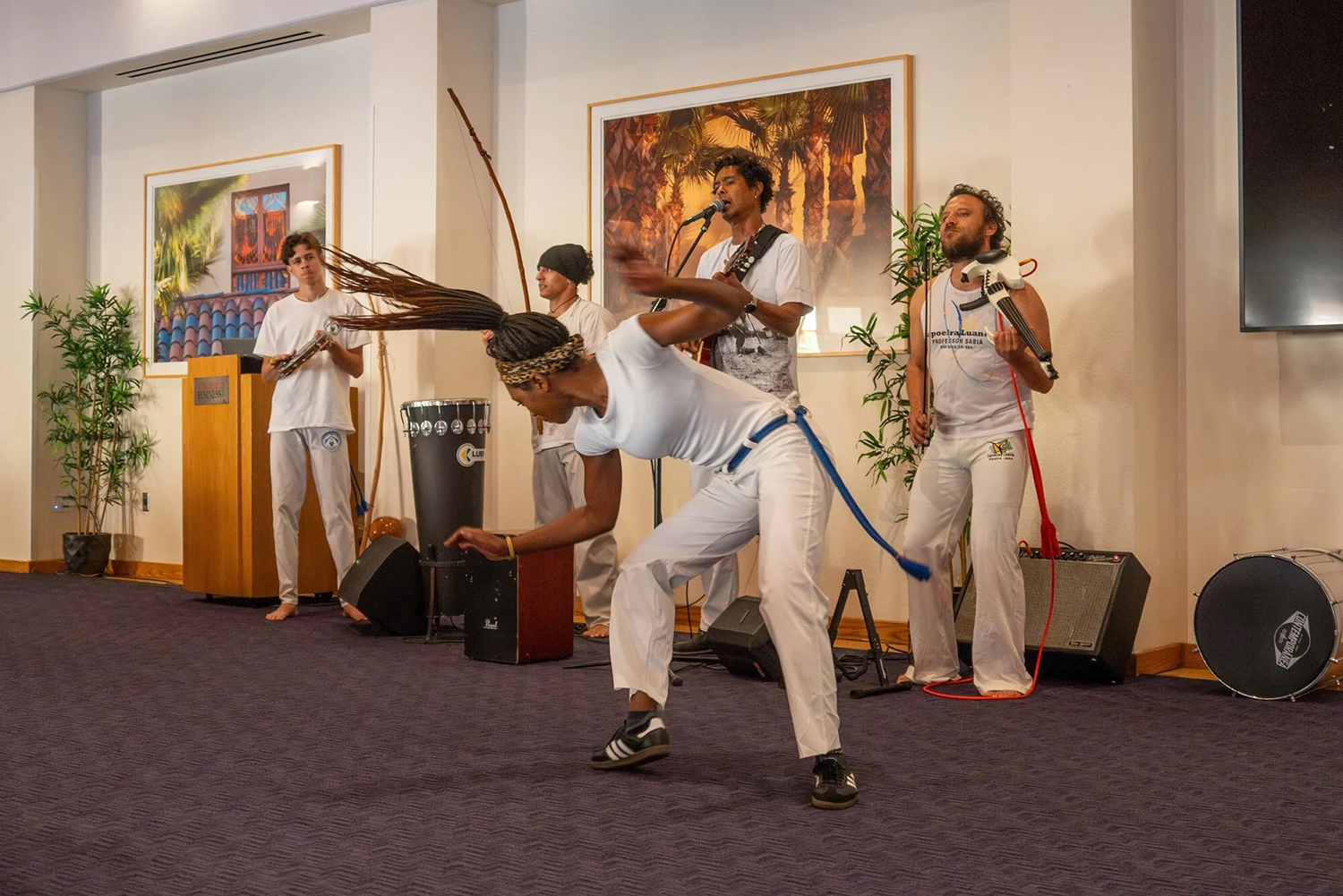 A dancer performs capoeira accompanied by musicians playing traditional instruments.