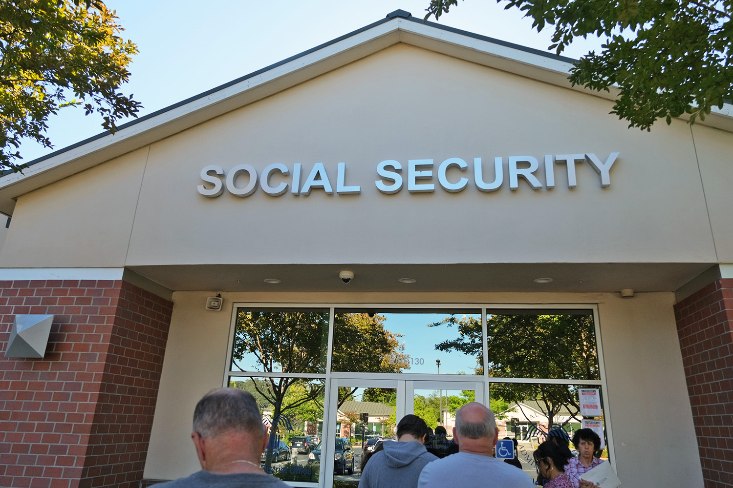 People waiting in line in front of a Social Security building.
