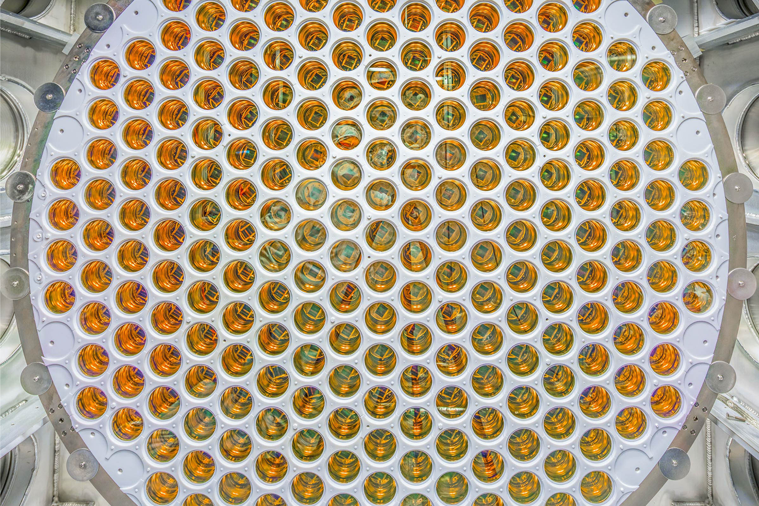 Close view of a circular array of hundreds of gold-toned light sensors packed into a white panel.