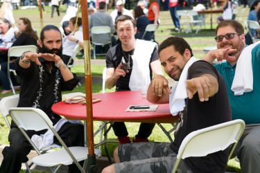 co-workers from the Stanford Libraries Dion Aragon, left, Randy Steele, and Caleb Cochran with Don Cameron of University IT sitting around a picnic table