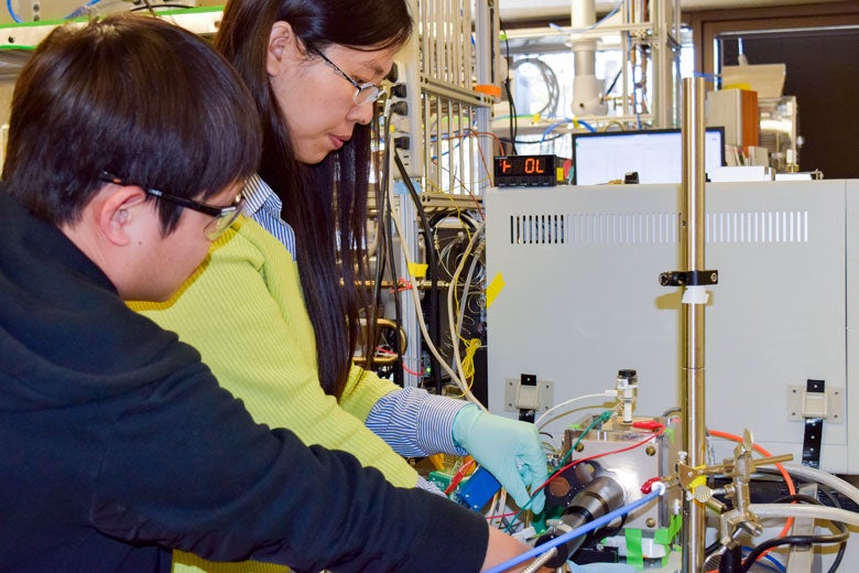 Xiaofei Ye (left) and Liming Zhang adjusting experimental device