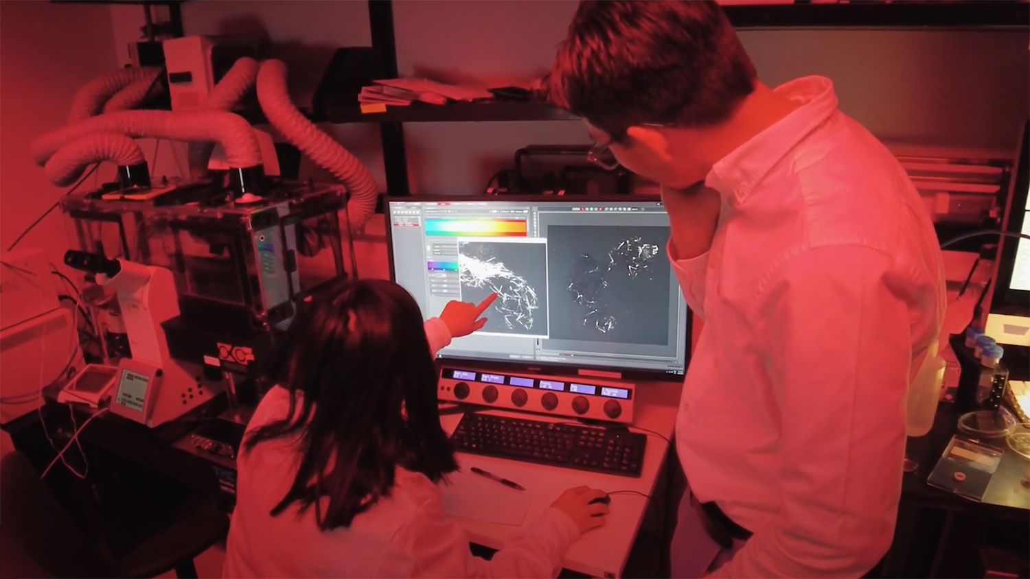 Researchers in a neuroscience lab looking at images on computer screeen