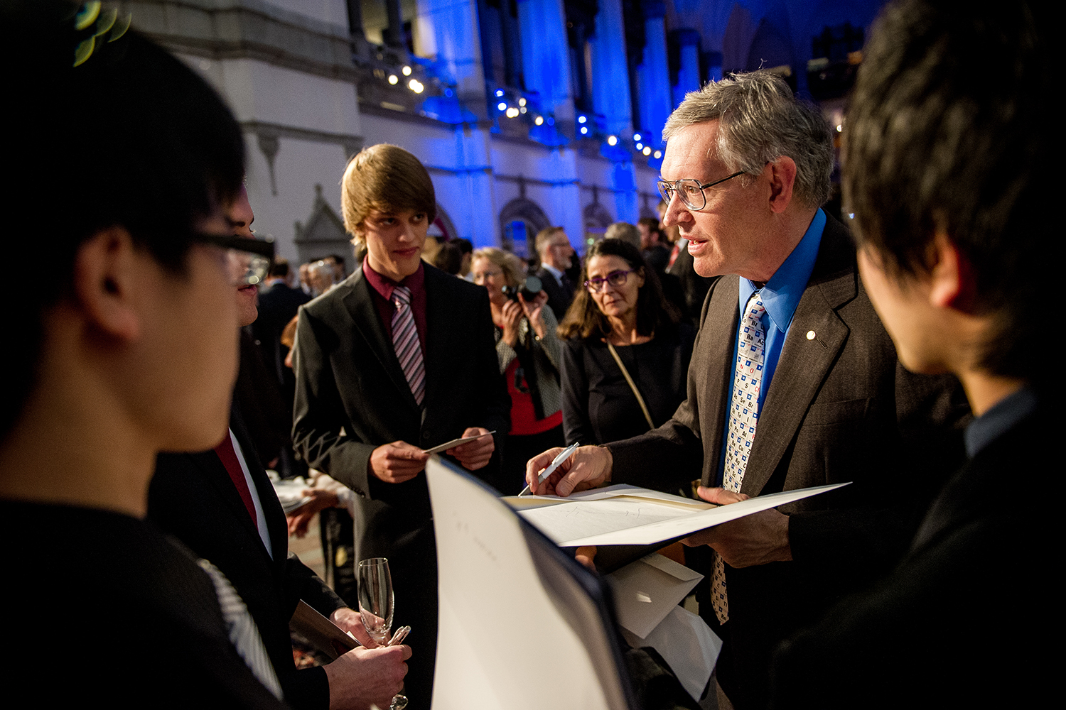 W.E. Moerner autographs posters during the Nobel Foundation reception at the Nordic Museum in Stockholm. 