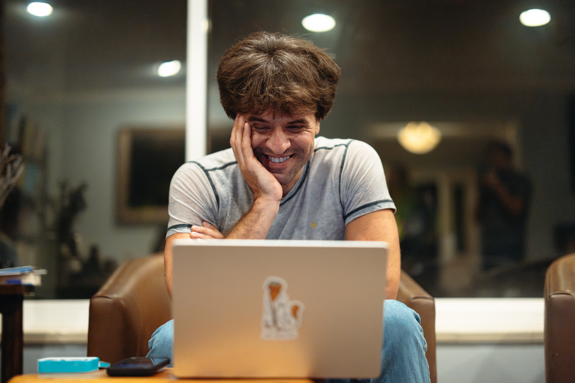 Karl Deisseroth rests his cheek on his hand while looking at a laptop.