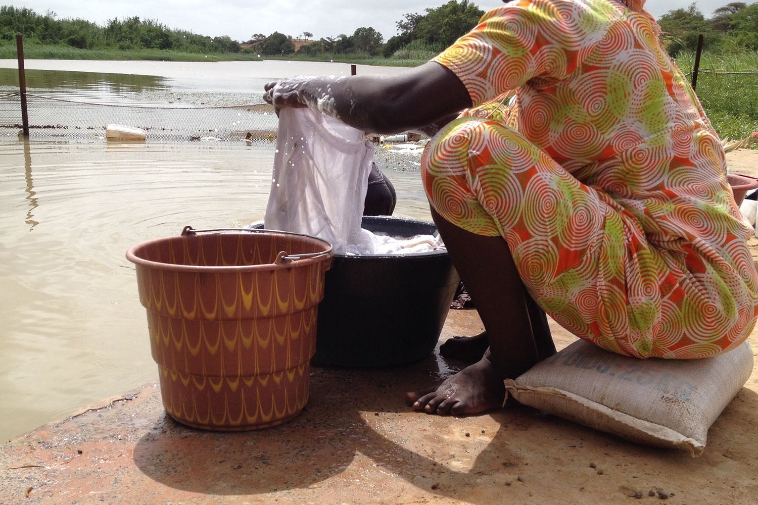 A woman washes clothes in the Senegal River.