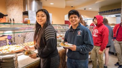 Students selecting food from a bar.