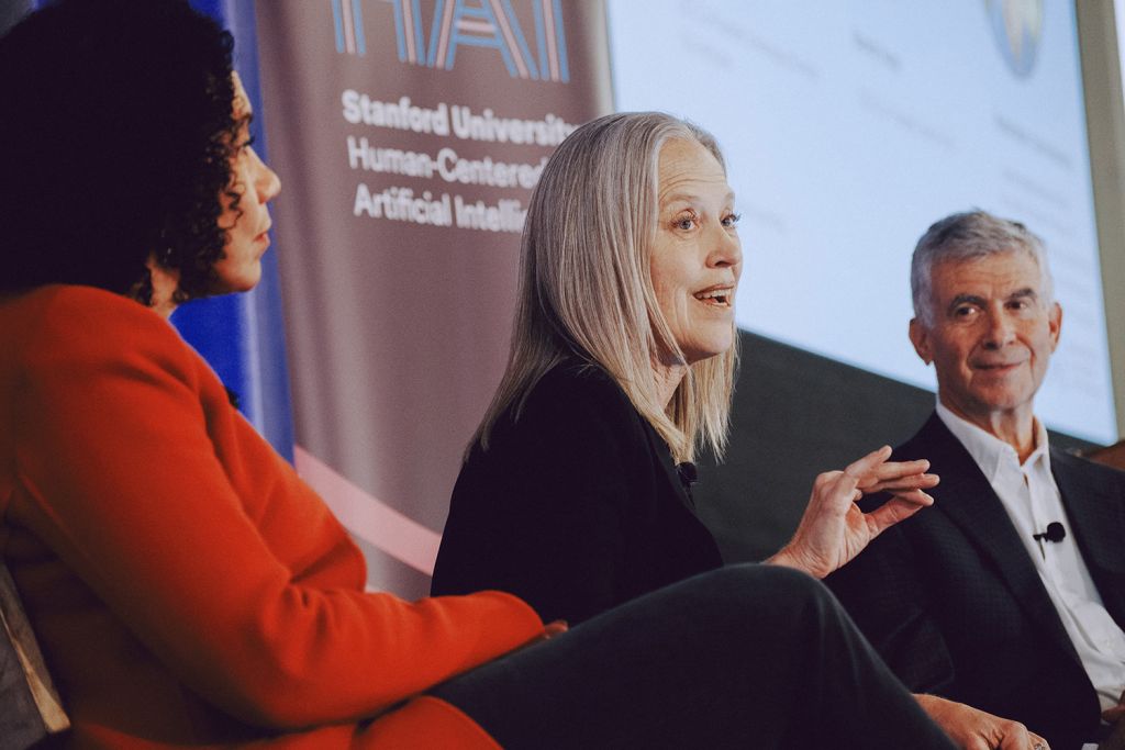 Panelists including Wendy Kopp, center, in discussion onstage, with Stanford HAI banner in background.