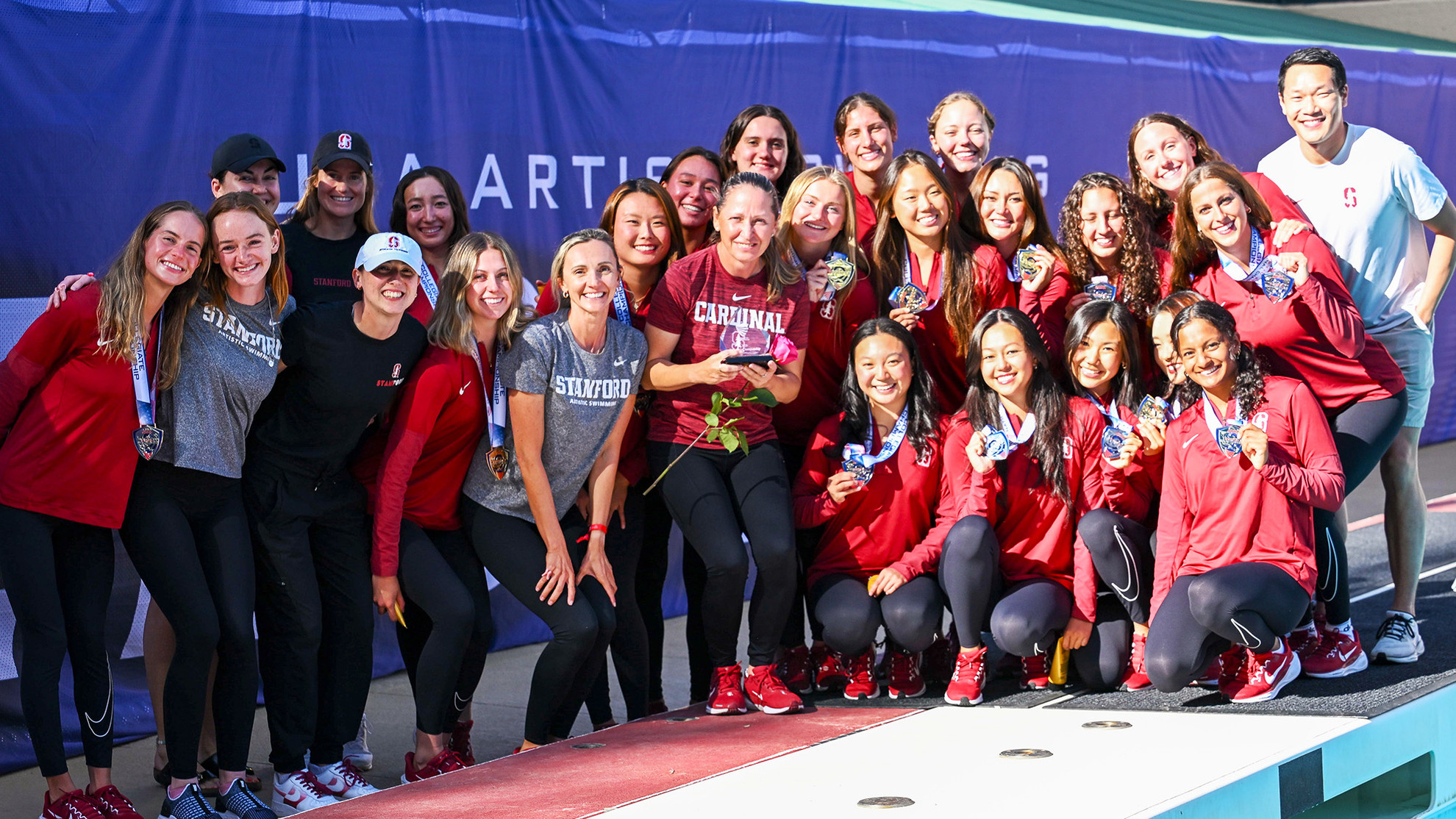Stanford's artistic swimming team posing with their medals after winning the USA Artistic Swimming Collegiate National Championship title