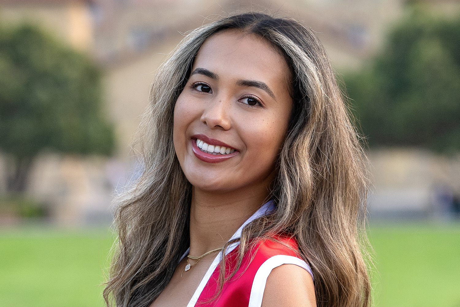 Ava Brown posing for a profile photo outdoors on the Stanford campus with Memorial Church blurred in the background.