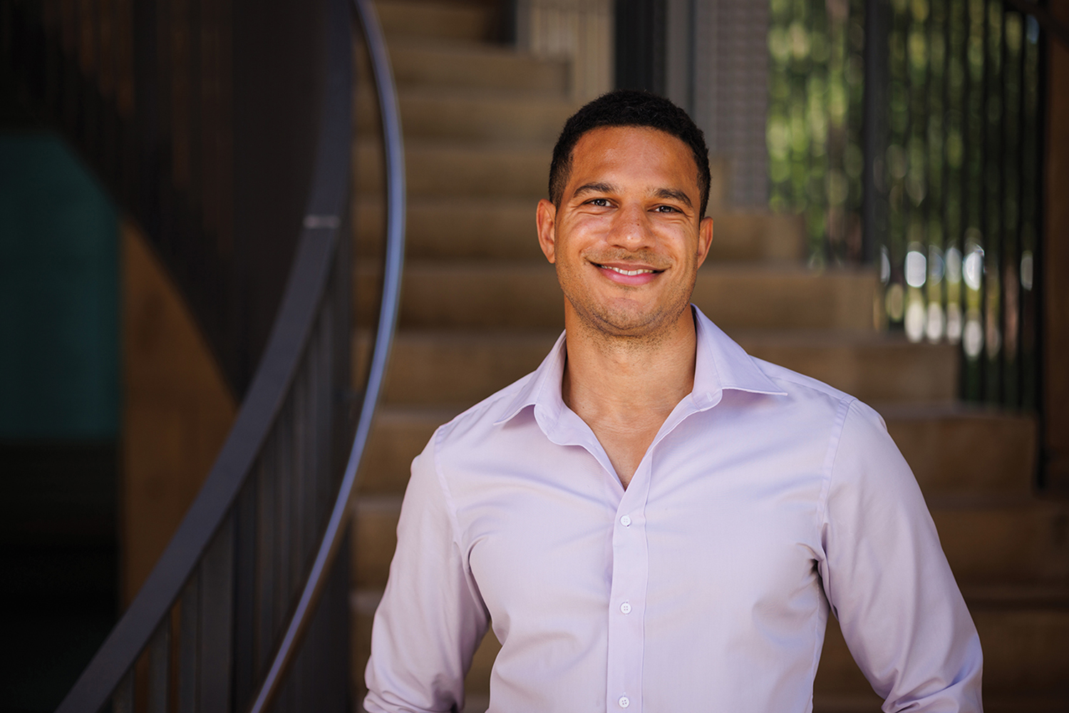 Julian Nyarko standing in front of a staircase and posing for a profile photo.