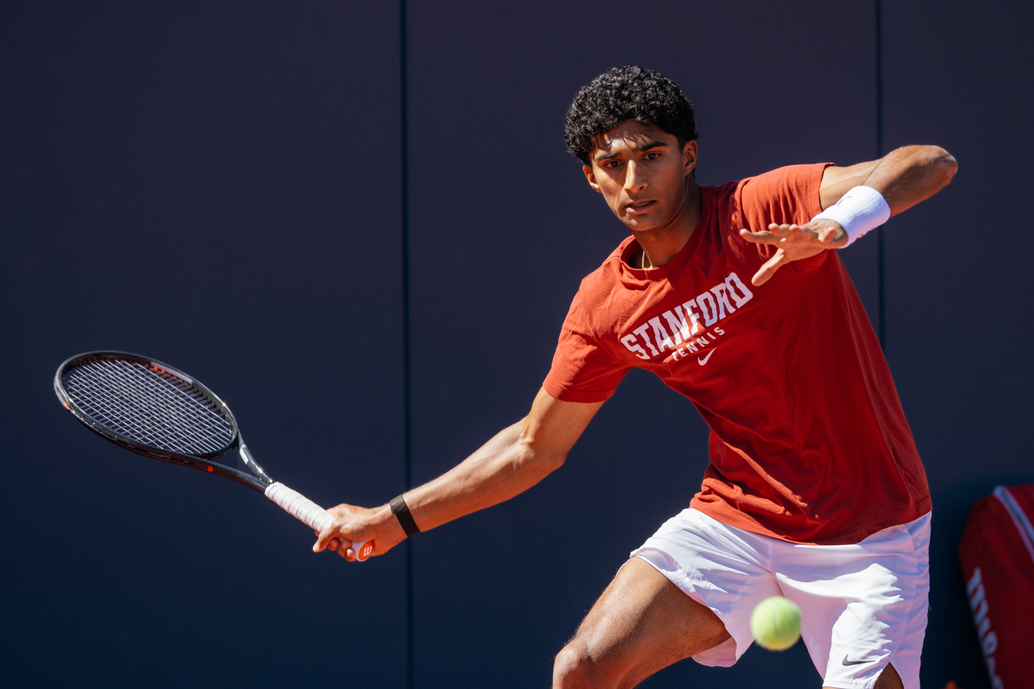 Samir Banerjee extends his racket during a match to hit a forehand.