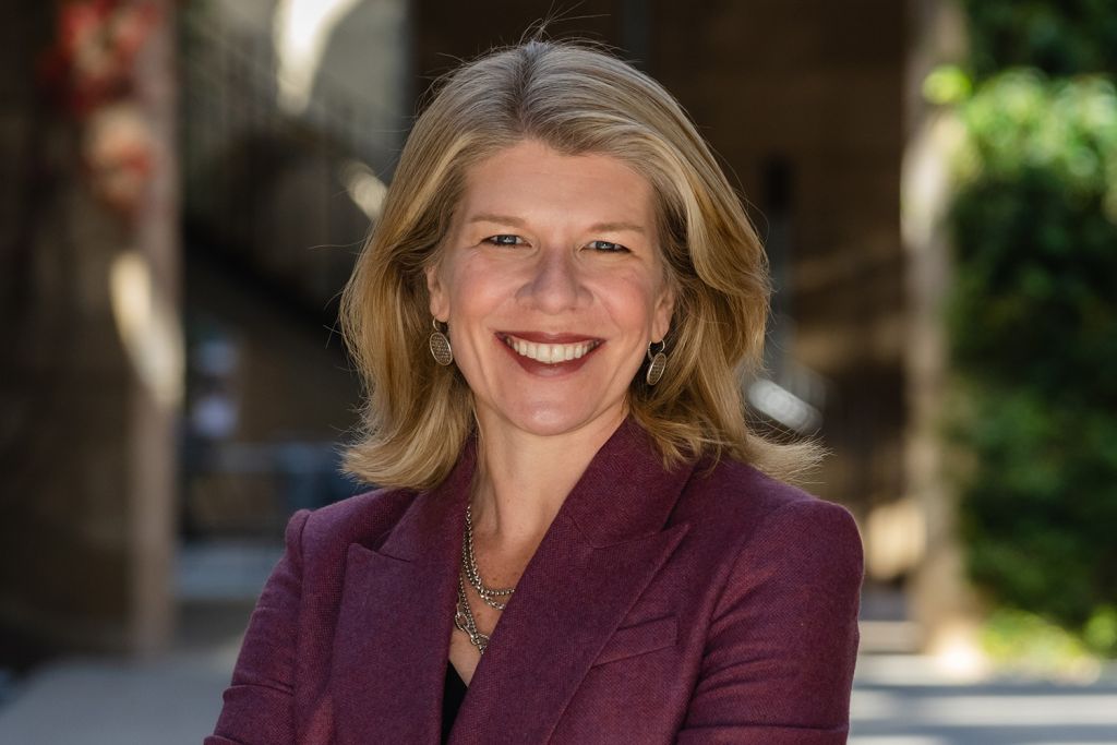 Nora Freeman Engstrom smiling and posing for a profile photo outdoors on the Stanford campus.