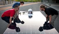 People lifting a solar panel.