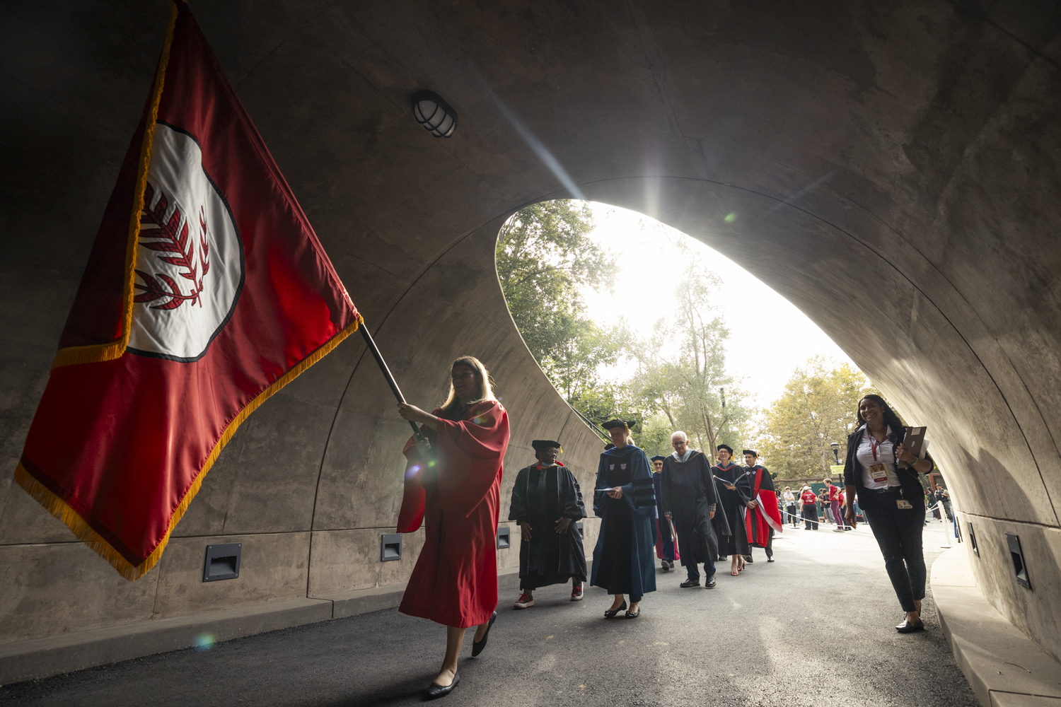 Faculty process behind university flag into Frost Amphitheater for Opening Convocation