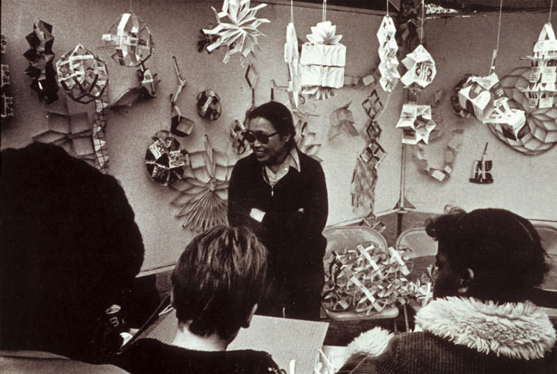 Ruth Asawa in classroom teaching geometric patterns made from milk cartons, c. 1981. 