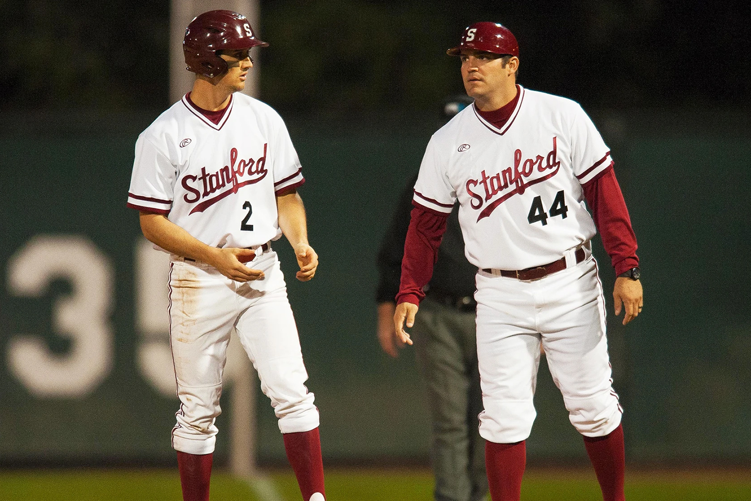 Stanford baseball players, both in white jerseys, during a game.