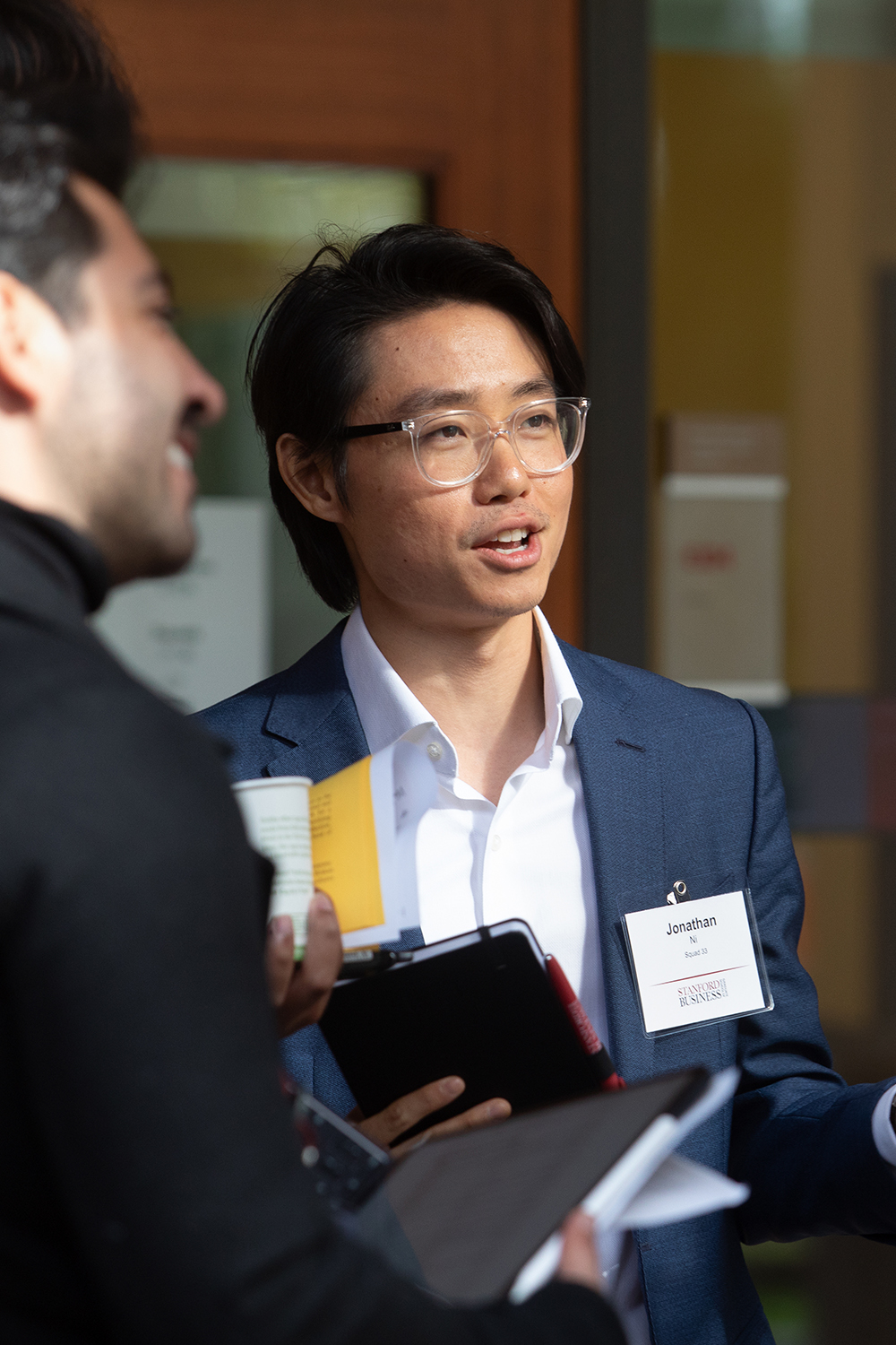 A person in business attire is engaged in conversation outdoors during a networking portion of the event.