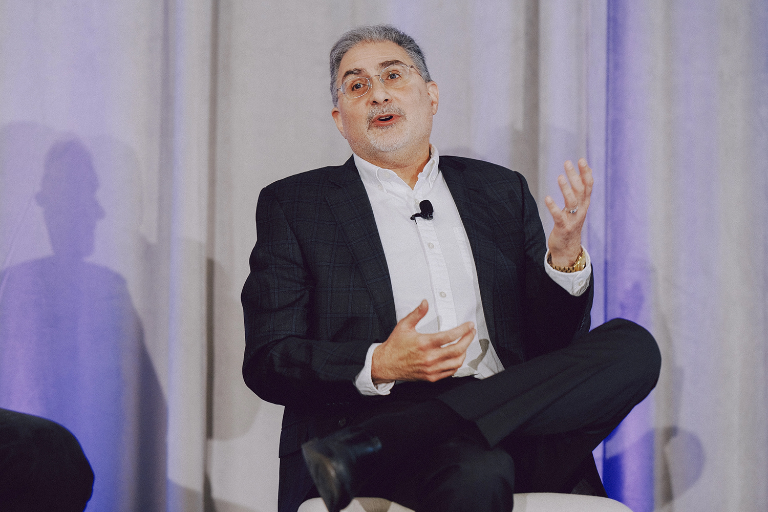 Mehran Sahami, seated onstage, gestures while discussing topics at a panel event.