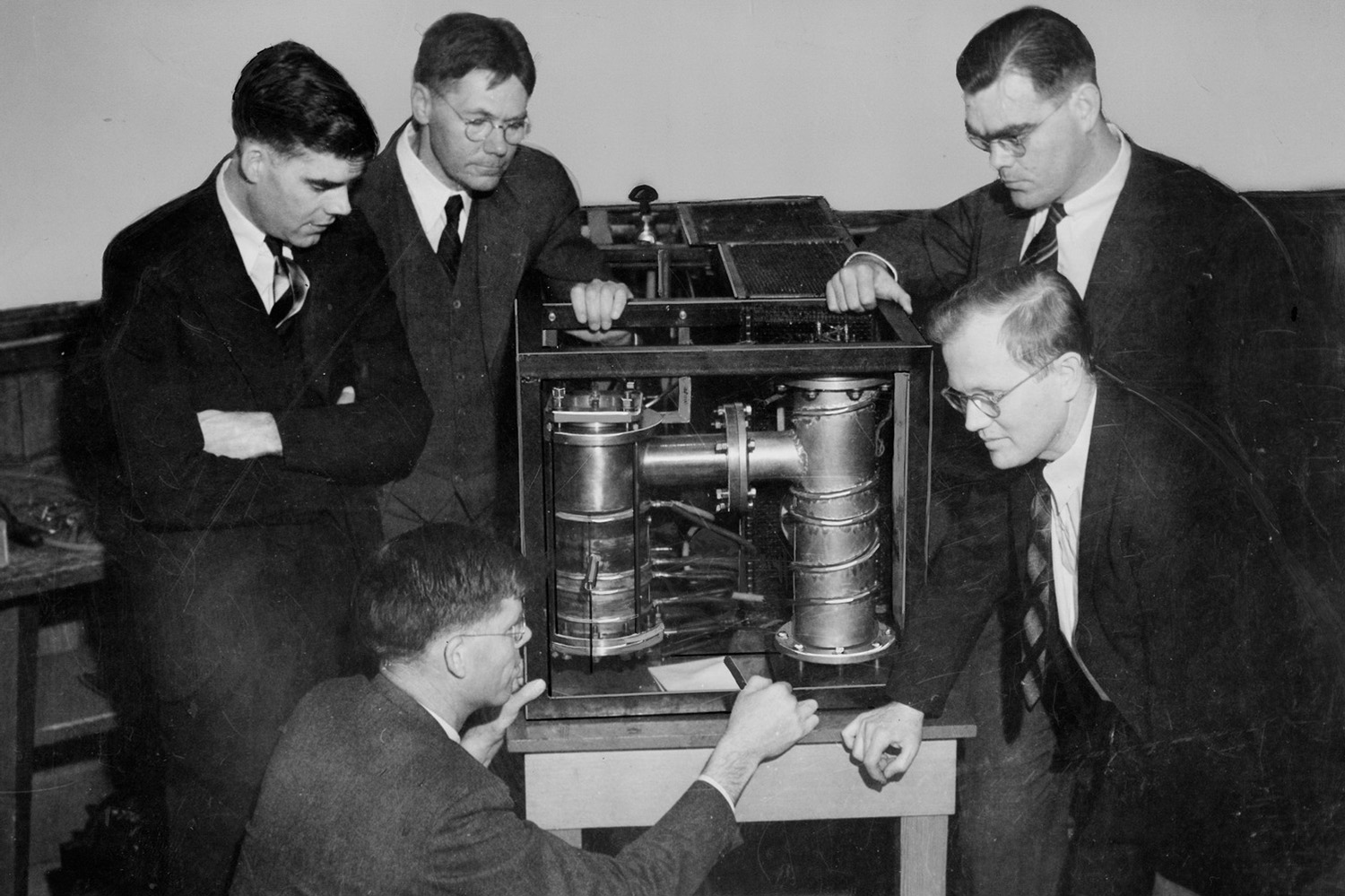 Researchers in suits gathered around an early klystron.