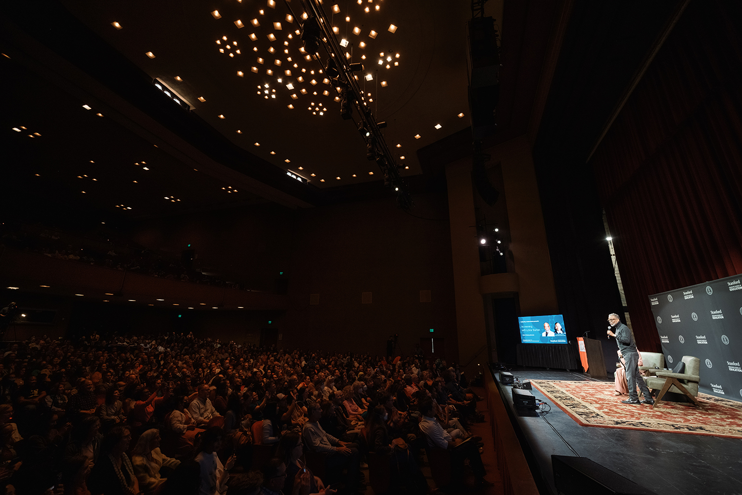 LeVar Burton presents on stage in front of a large audience.