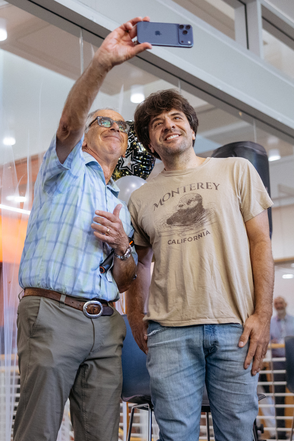 Russ Altman takes a selfie with Karl Deisseroth in front of celebration balloons.