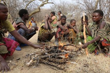 Members of the Hadza, a hunter-gatherer population in Tanzania, gathered around a fire.