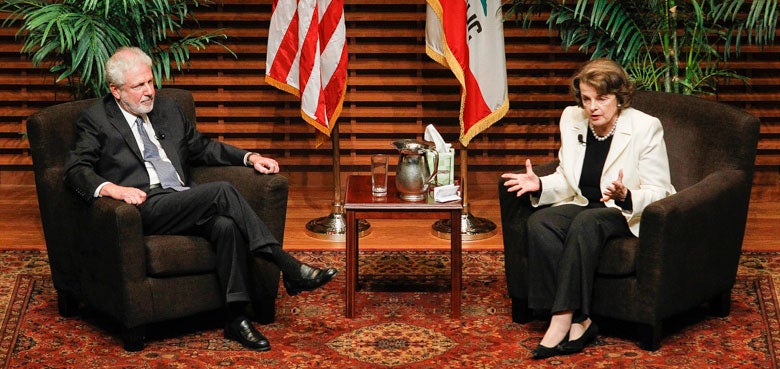 Philip Taubman and Dianne Feinstein speaking from the stage at Cemex Auditorium.