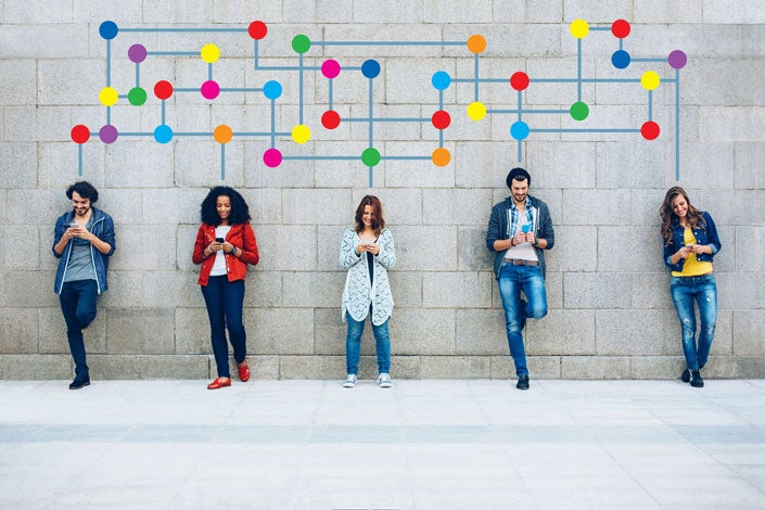 people standing against a wall interact with their phones; a graphic is superimposed to show their connections