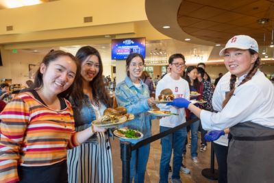 Students, chef holding plates of food.