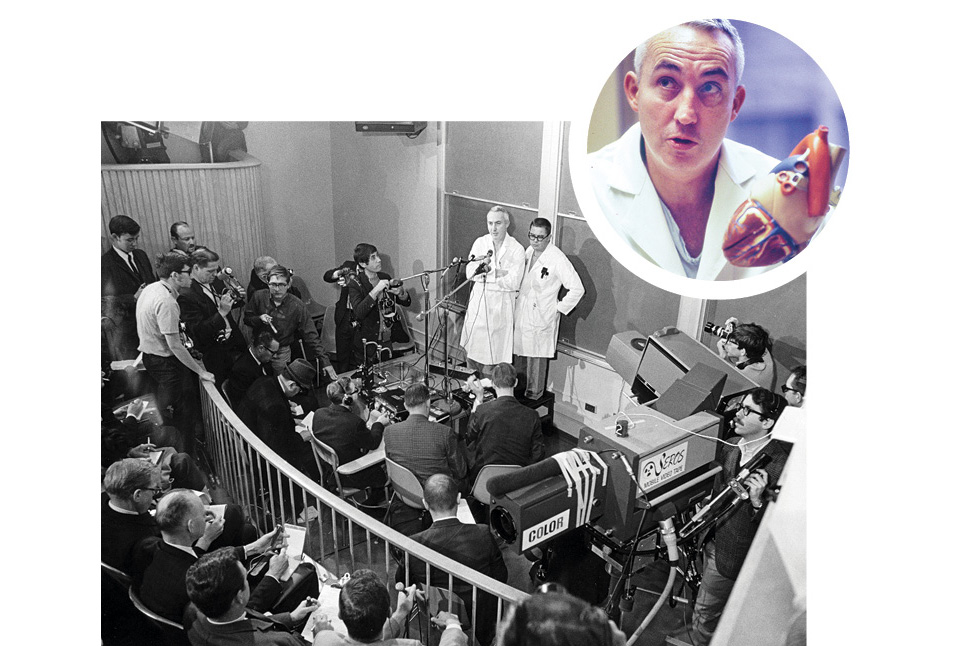 Doctors in white coats presenting to a crowded room of reporters and photographers with cameras and equipment.