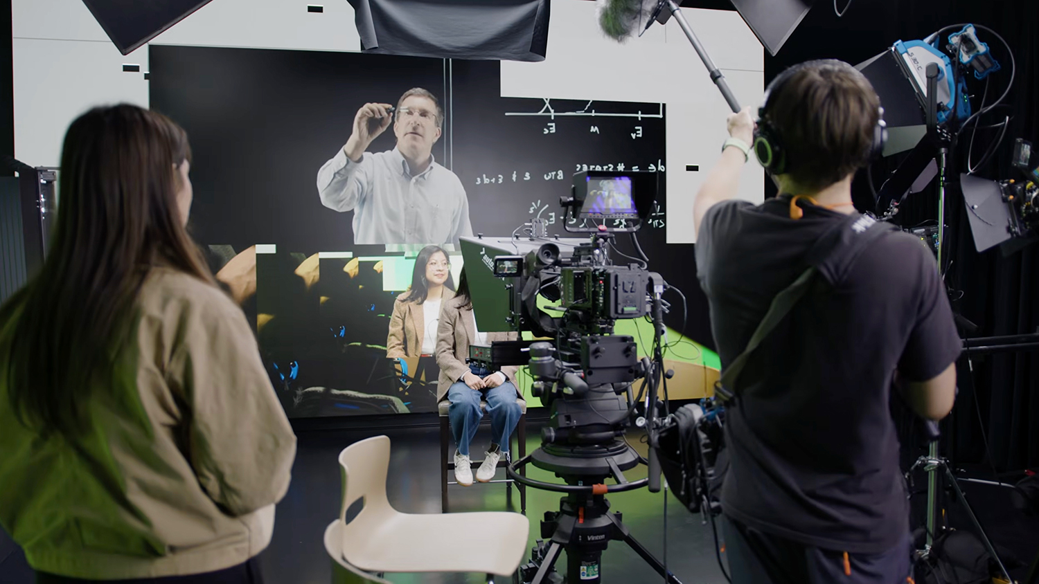 Film crew producing video content on a green screen set with professional cameras and lighting equipment.