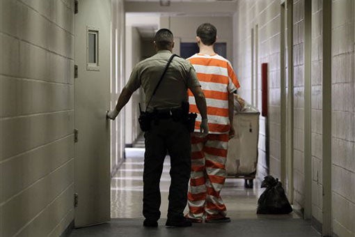 prisoner and guard walking down corridor