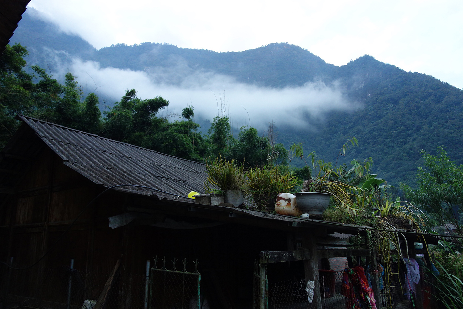 Photo of a house in the mountains of Sa Pa, Vietnam, covered in a cloud of fog.