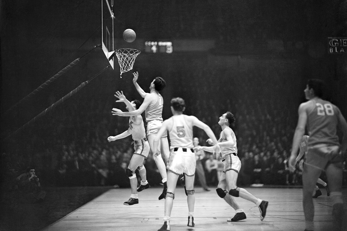 Basketball player Hank Luisetti making a one-handed jump shot.