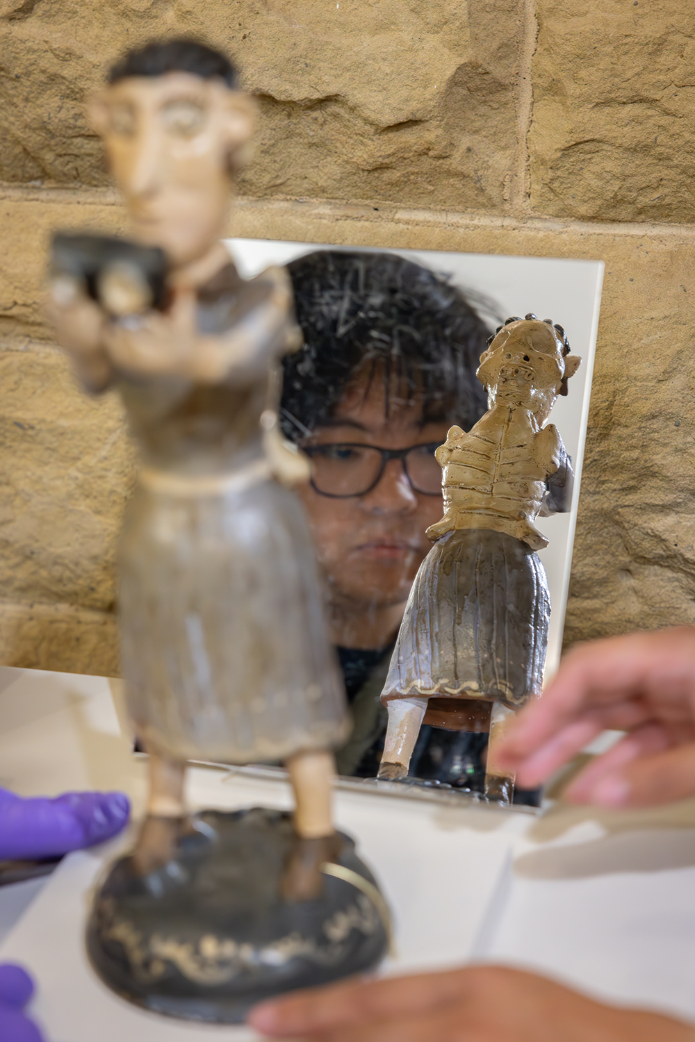 Pictured is a mirror that was set up to reflect the back of a figurine on display.