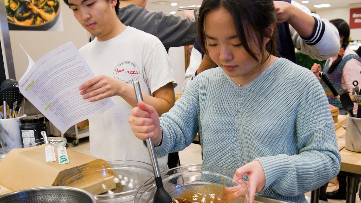 Students in the Edible Materials course stir a bowl of melted chocolate.
