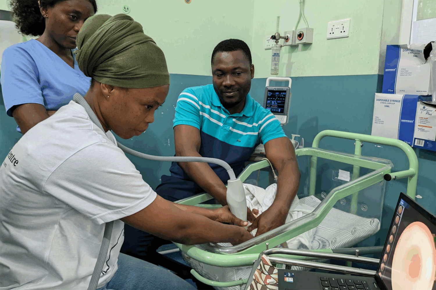 Image of a community health worker, takes images of a baby’s eyes for evaluation for retinopathy.