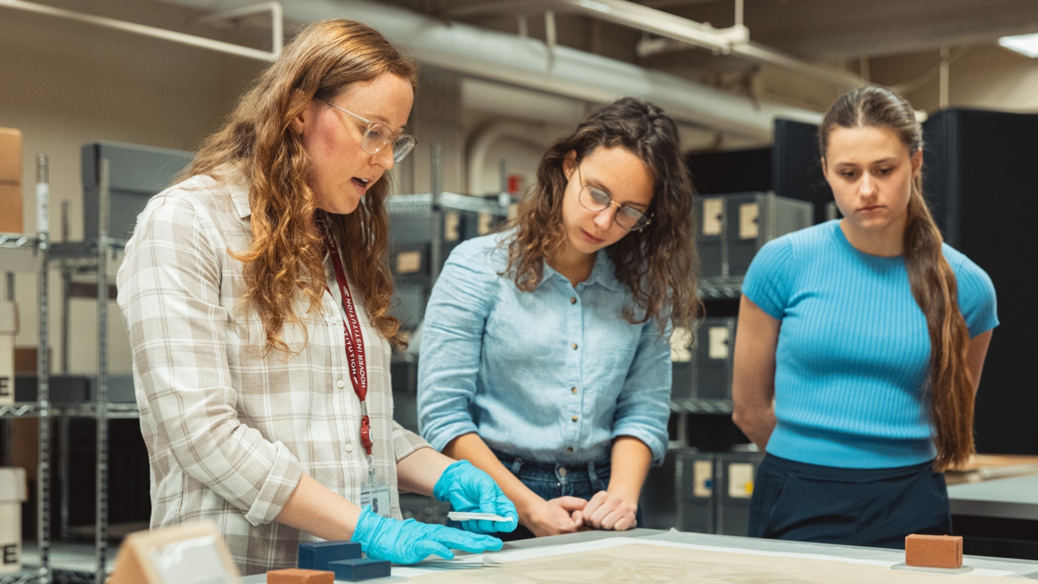 Three people focus on examining materials together.