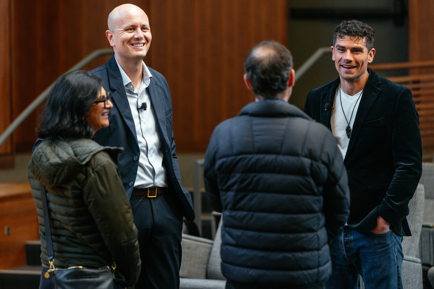 Luke Kemp chats with attendees in an auditorium after a presentation.