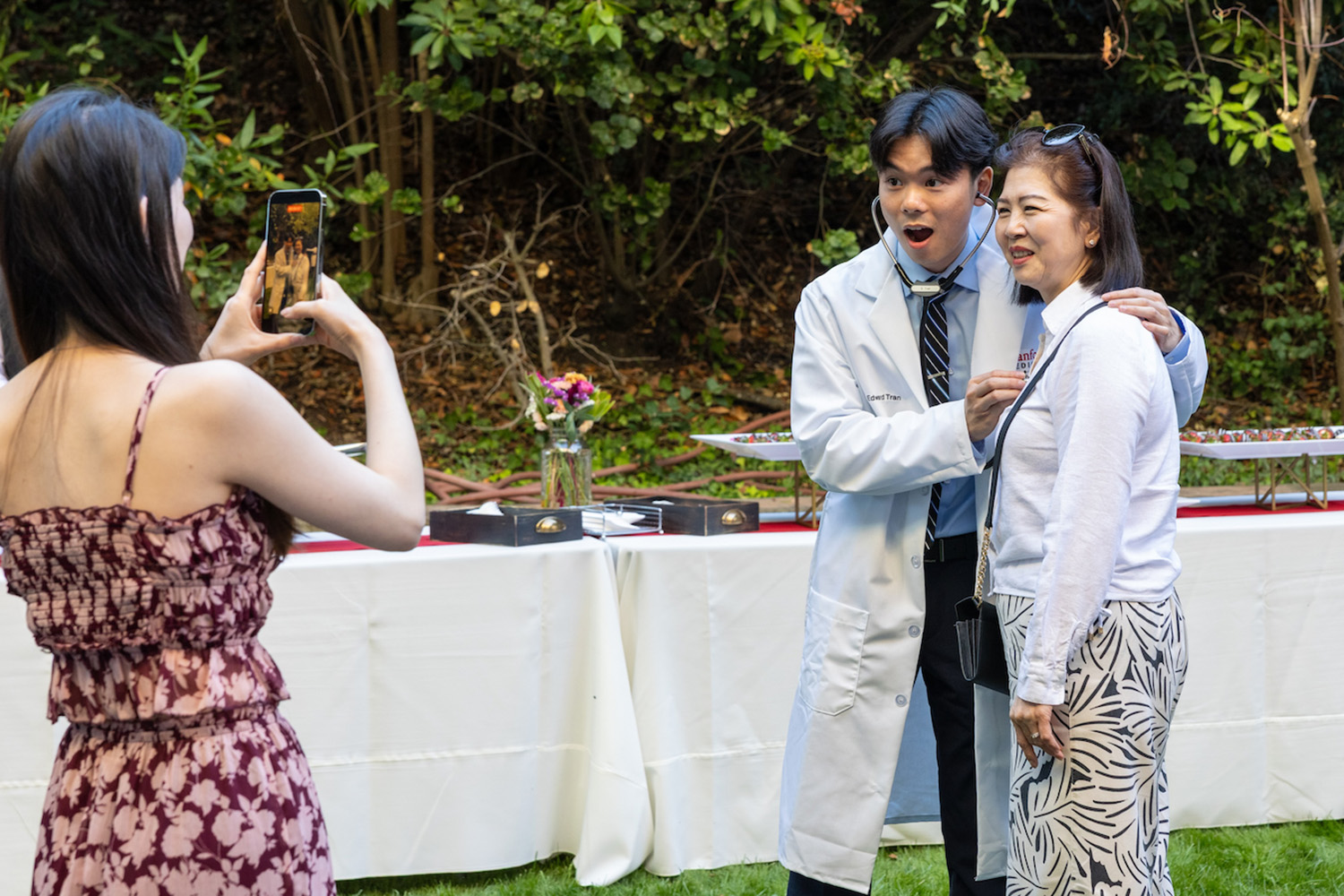Edward Tran poses for a photo with a member of his family during a white coat ceremony.