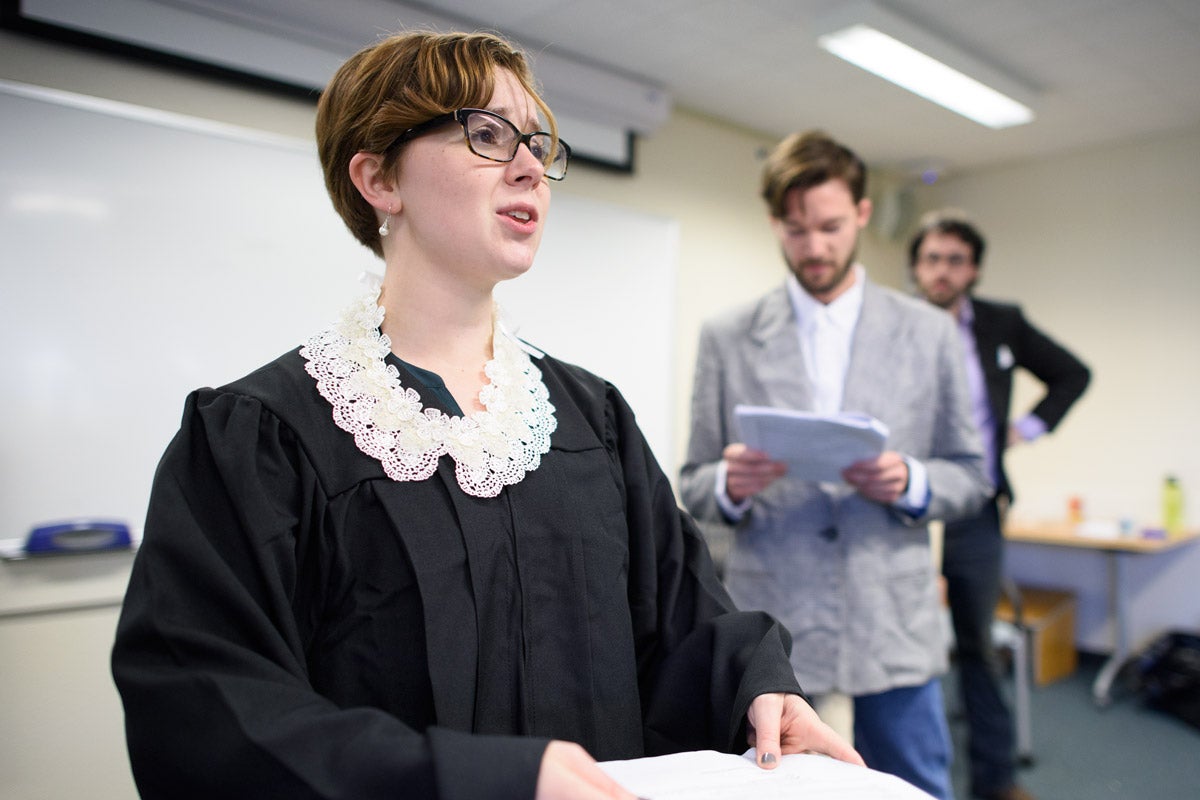 Stanford graduate students in classics translated and adapted an ancient Greek play to lampoon modern politics. In this scene from rehearsal, Lizzy Ten-Hove portrays Supreme Court Justice Ruth Bader Ginsburg while David Pickel portrays political strategist Steve Bannon and Kilian Mallon plays Liberty University President Jerry Falwell Jr.