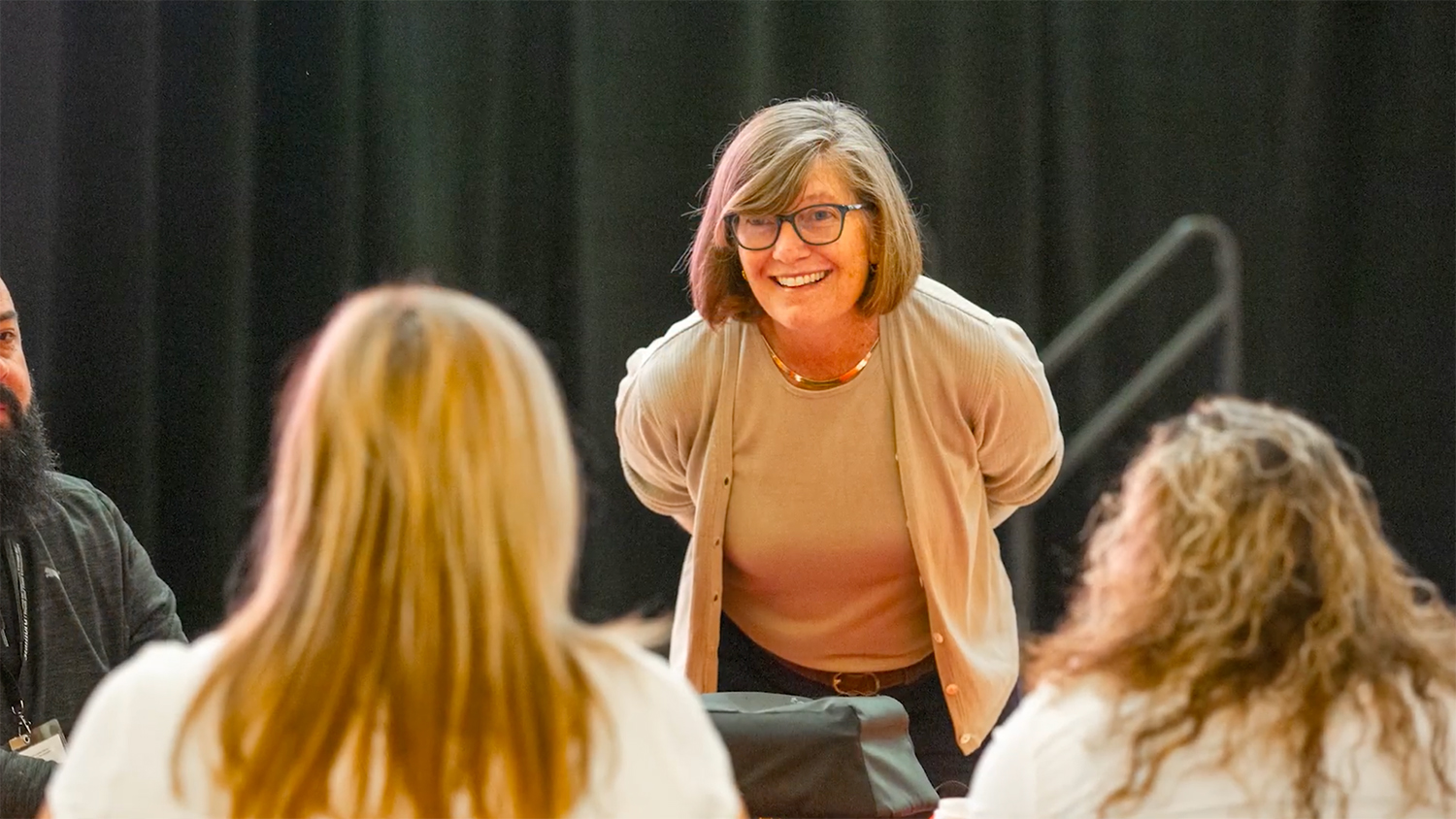Image of a person leaning in to listen to an event participant.