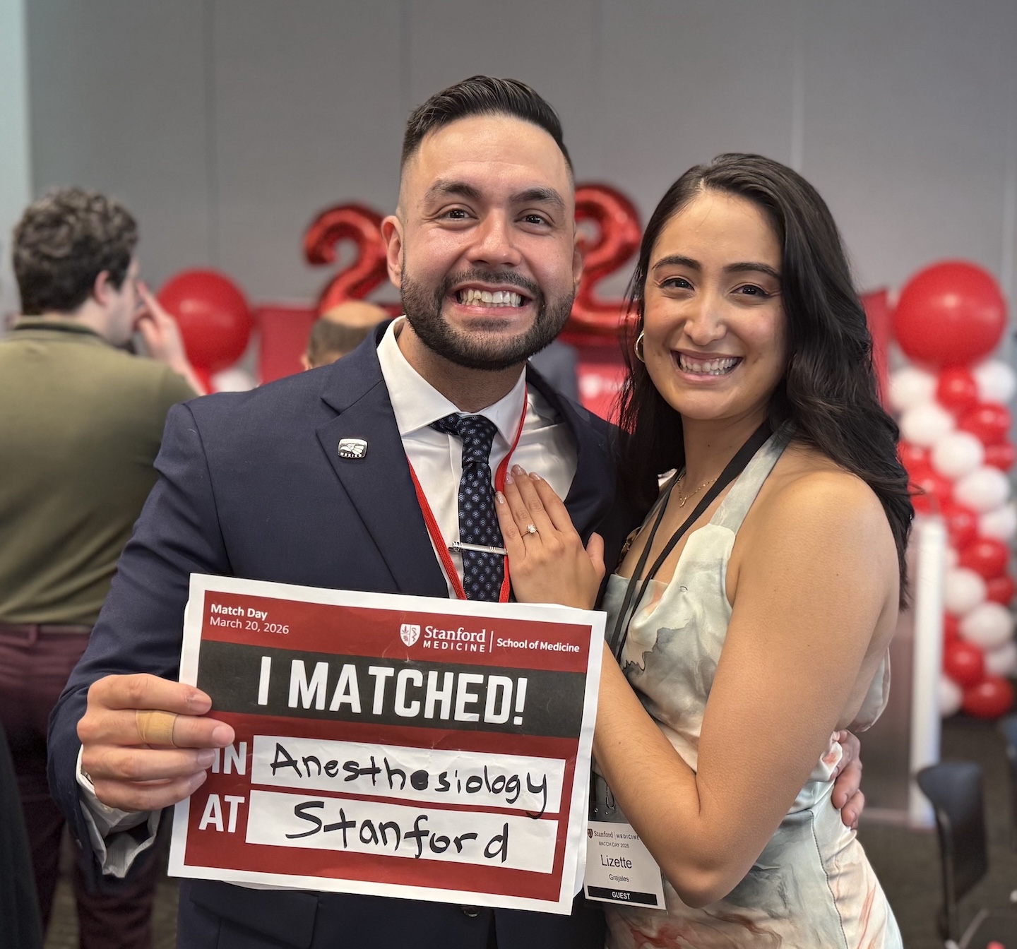 Samuel Castro poses for a photo with his fiancée while holding a sign saying where he will go for his residency.