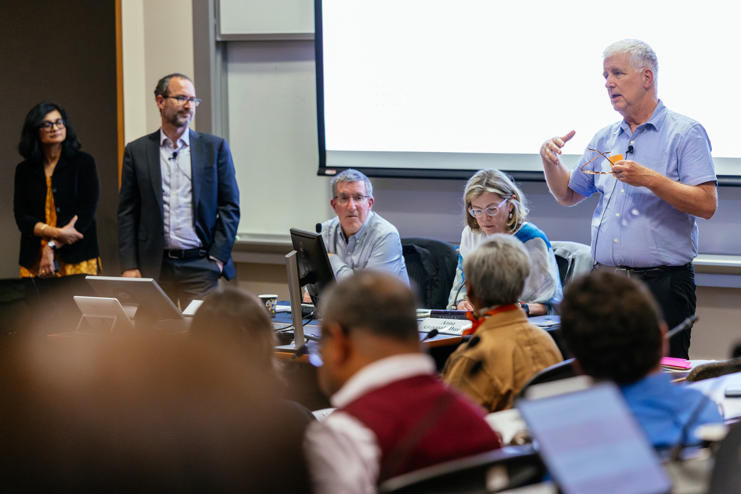 Jim Campbell addresses the Faculty Senate while the engaged audience listens in a law school classroom setting.