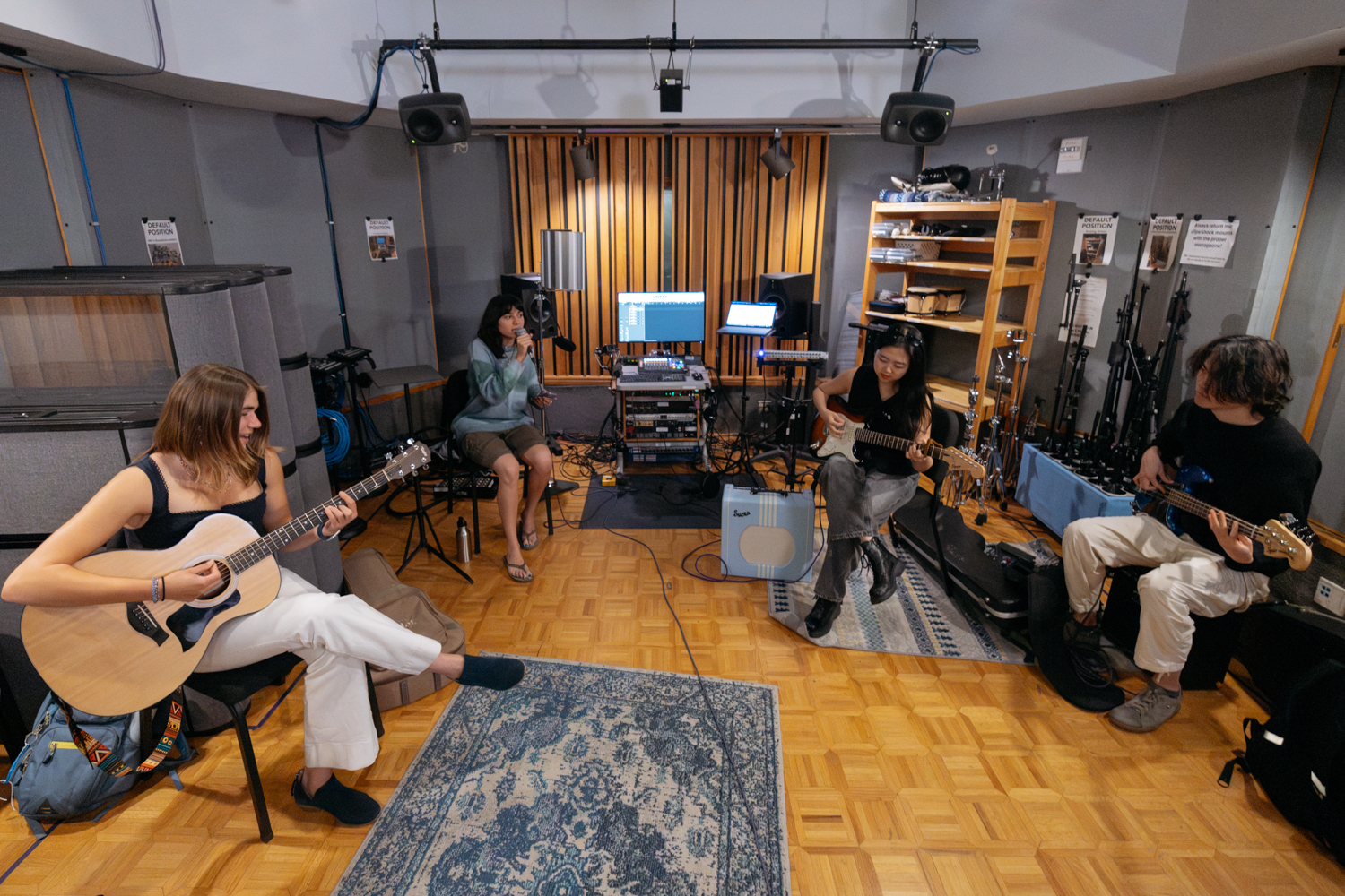 Four musicians practice together in a studio.
