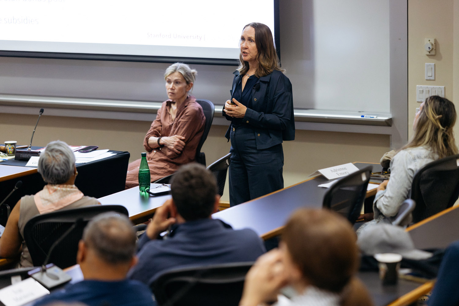Provost stands in front of Faculty Senate meeting, engaging with attendees during her presentation.
